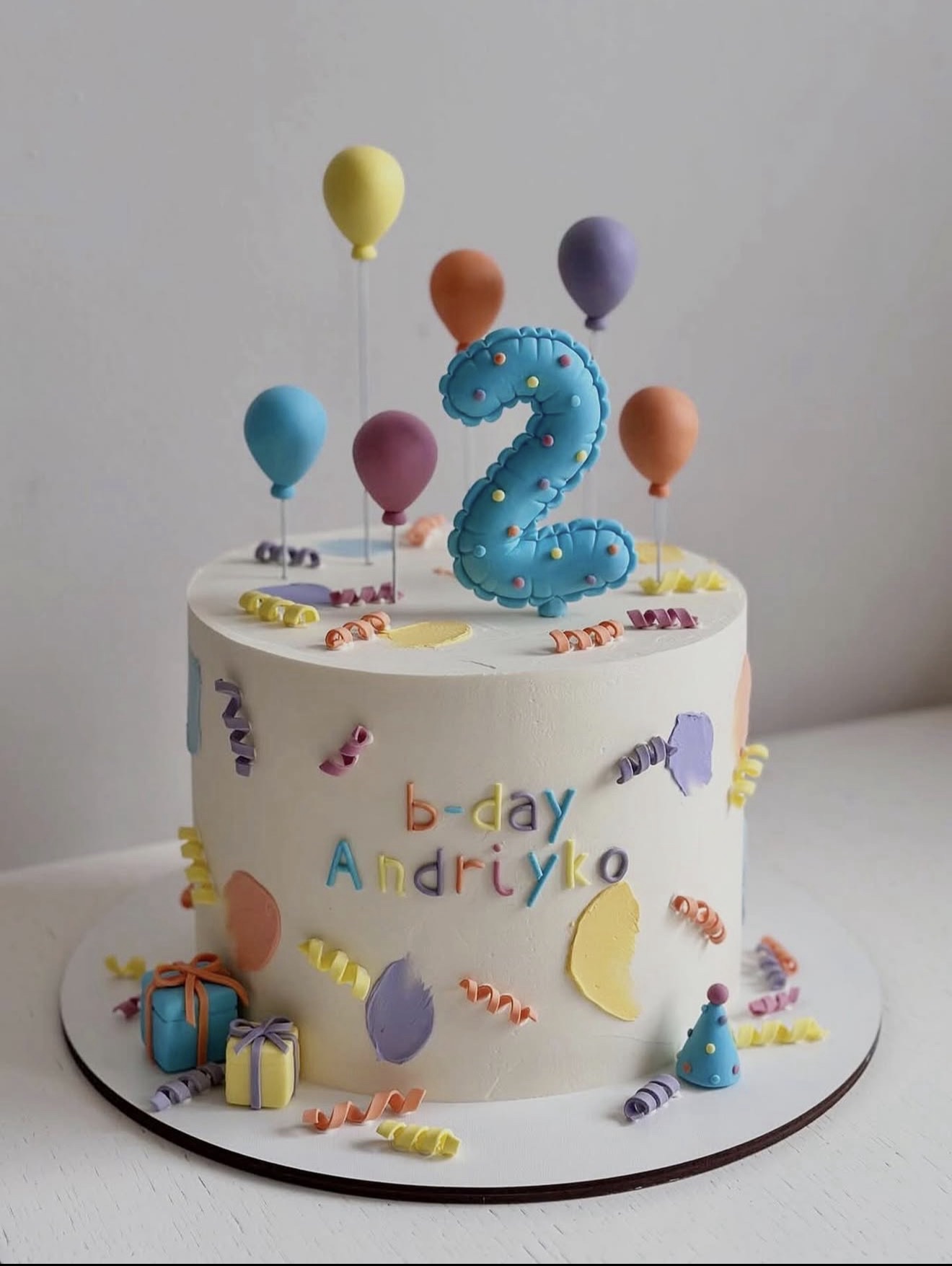 Colourful second birthday cake with balloons